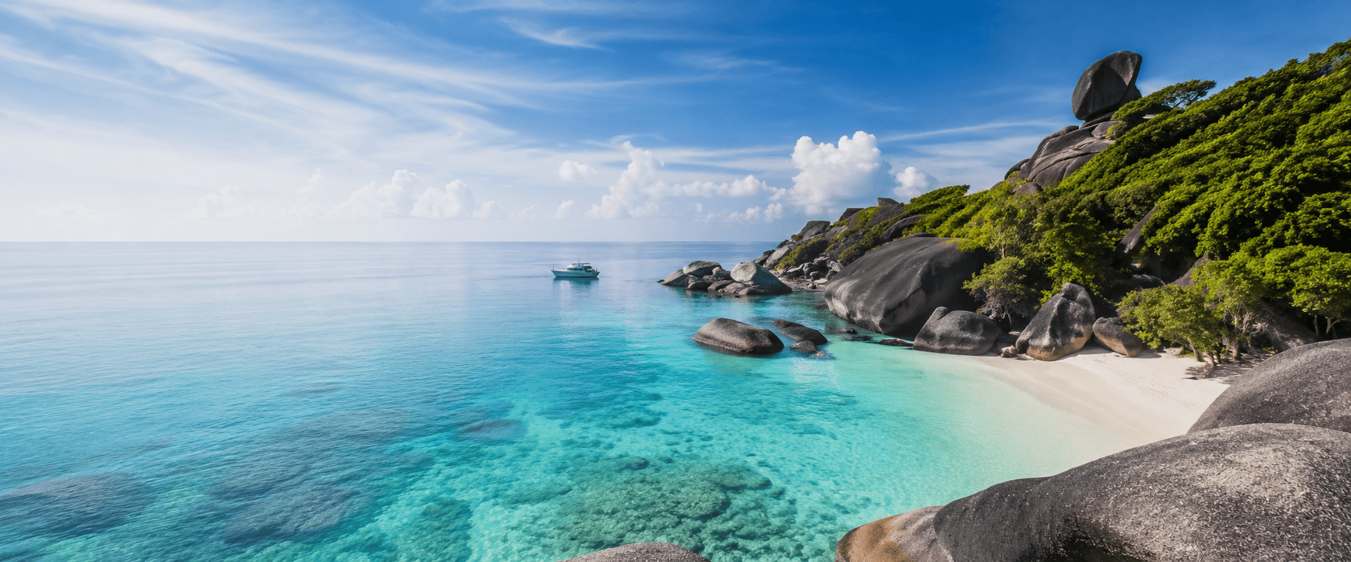 Snorkelers swimming above a coral reef near the Similan Islands, with granite boulders visible along the shoreline.
